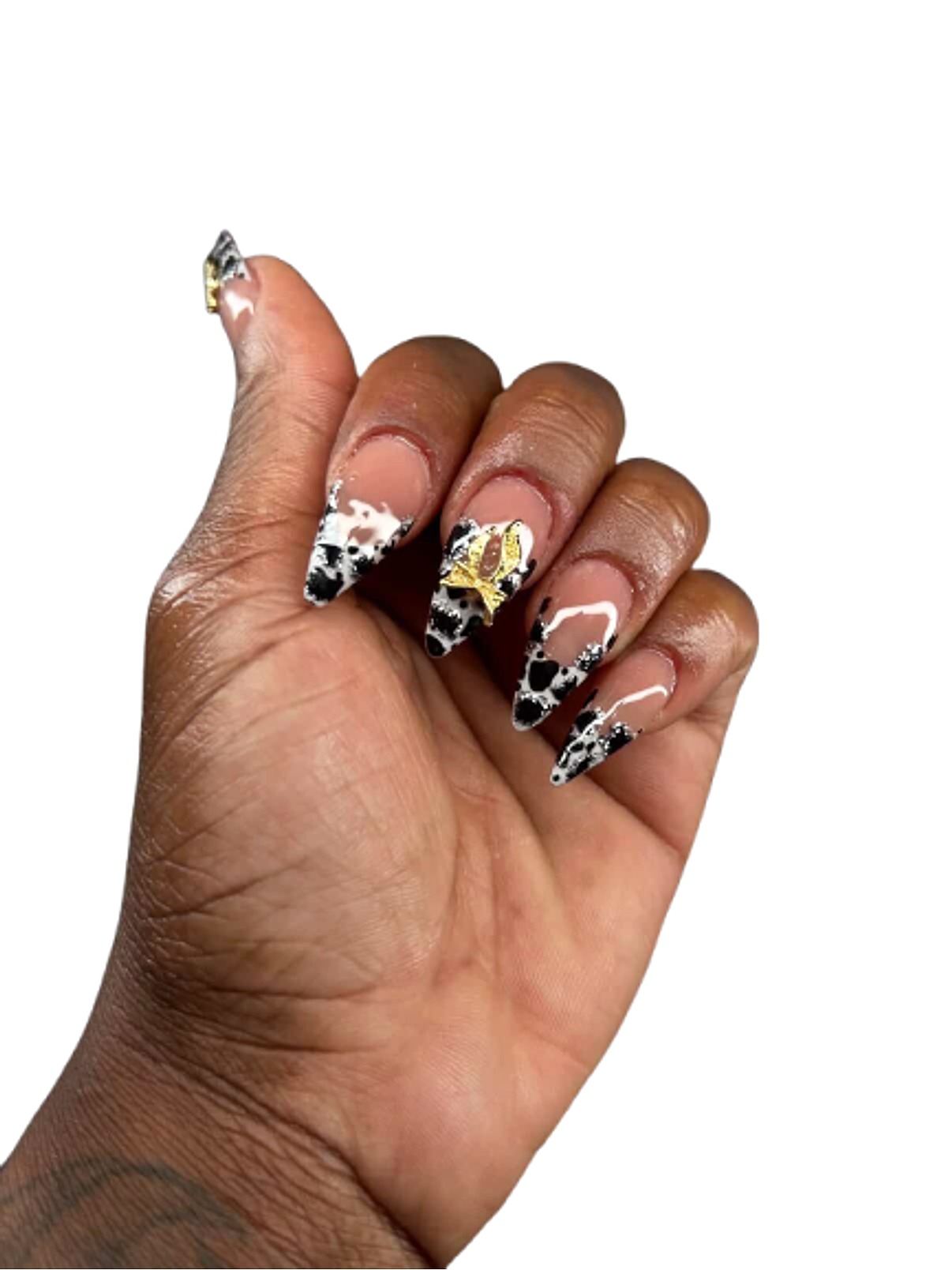 Cow print nails with gold charm